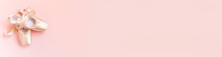 New pastel beige ballet shoes with satin ribbon isolated on pink background. Ballerina classical pointe shoes for dance training. Ballet school concept. Top view flat lay copy space bannerの写真素材