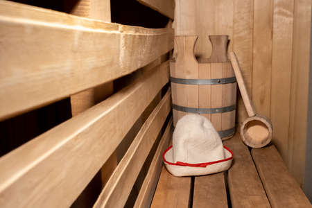 Traditional old Russian bathhouse SPA Concept. Interior details Finnish sauna steam room with traditional sauna accessories set scoop felt. Relax country village bath conceptの写真素材