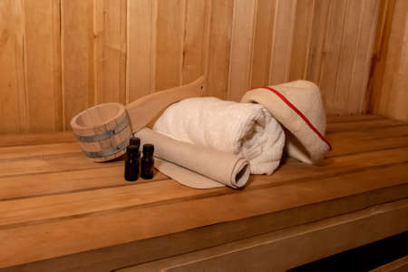Traditional old Russian bathhouse SPA Concept. Interior details Finnish sauna steam room with traditional sauna accessories set basin towel aroma oil scoop felt. Relax country village bath conceptの写真素材