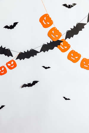 Trick or Treat concept. Holiday composition with halloween garland decorations pumpkins and bats isolated on white background. Preparation for Halloween party. Autumn fall happy Halloween.の写真素材