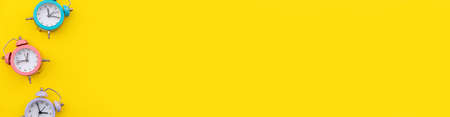 Simply minimal design three ringing twin bell classic alarm clock Isolated on yellow background....