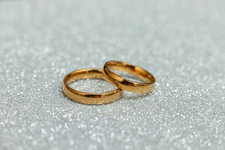 Will you marry me. Two golden wedding rings on silver glitter background. Engagement marriage proposal wedding concept. St. Valentines Day postcard. Banner on valentines day. Copy spaceの写真素材