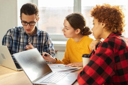 Focused female team leader discuss financial statistics brainstorming business meeting with partners clients at office. Lady boss leader young businesswoman. Diverse corporate professional teamの写真素材