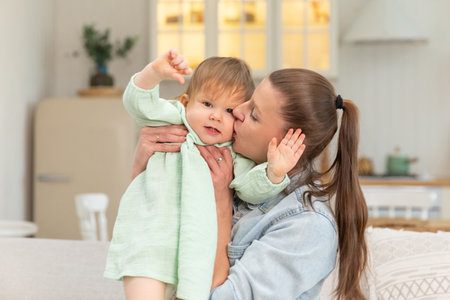Happy family at home. Mother lifting in air little toddler child daughter. Mom and baby girl playing...