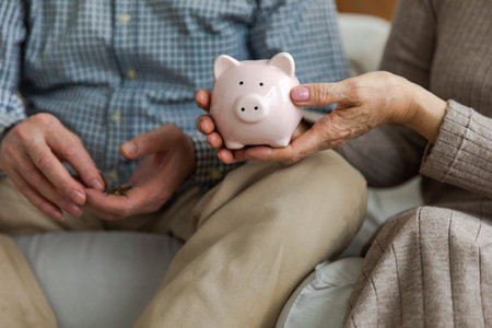 Saving money investment for future. Senior adult mature couple hands holding piggy bank with money coin. Old man woman counting saving money planning retirement budget. Investment banking conceptの写真素材
