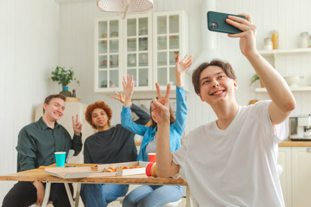 Cheers Funky mood. Happy group of friends make selfie. Man taking photo of friends at party. Group of multiracial young people taking photo on phone. Young people enjoy their company smile have funの写真素材