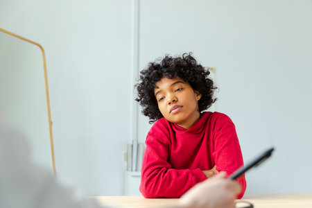 Young african american woman patient and female doctor in doctor office. Girl patient and doctor have consultation in hospital room. Medicine healthcare medical checkup concept. Visit to doctorの写真素材