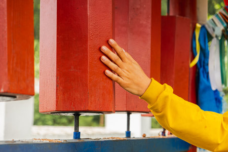 Person pilgrim female hand touching turning spinning Buddhist prayer wheel at Buddhist monastery....