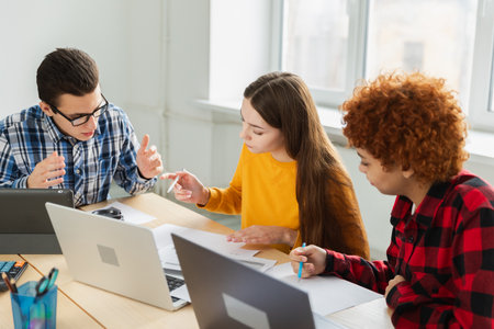 Teamwork brainstorm. Diverse colleagues working together discuss financial statistics. Group of happy young modern people sitting in creative office discussing business. Young professional teamの写真素材
