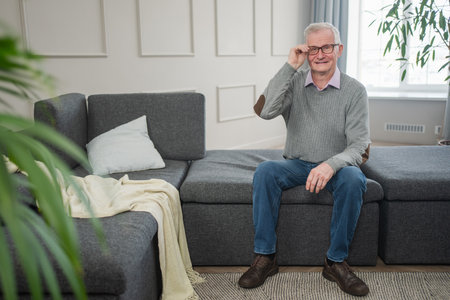 Portrait of confident stylish European middle aged senior man at home. Older mature 70s man smiling....