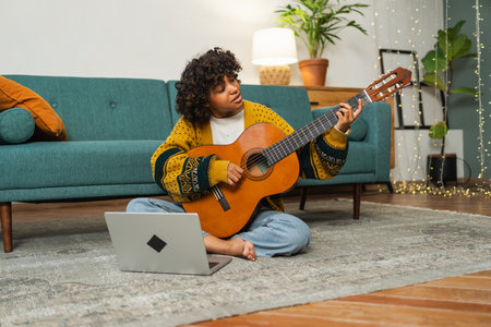 Blogger guitarist. Happy African American girl blogger playing guitar singing song recording vlog....