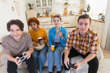 Home party. Cheerful group of friends playing video games at home. Happy diverse group buddies...