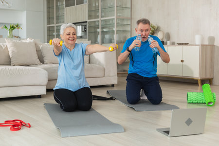 Fitness workout training. Senior adult mature healthy fit couple doing sports exercise on yoga mat on floor at home. Mid age old husband wife have training workout. Health care healthy lifestyleの写真素材