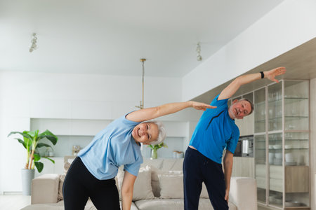 Fitness training. Senior mature healthy fit couple doing sports exercise at home. Mid age husband wife have training workout. Health care healthy lifestyle. Workout rehabilitation for old man womanの写真素材