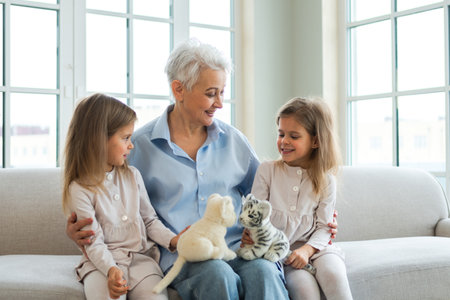 Happy family at home. Two little girls sisters twins grandmother enjoying time together. Good time at home. Grandma granddaughters child kids playing toys hugging together. Family generationsの写真素材