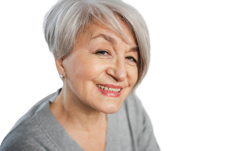 Confident stylish European middle aged senior woman. Older mature lady smiling isolated on white background. Happy attractive senior female looking camera close up face headshot portrait. Happy peopleの写真素材