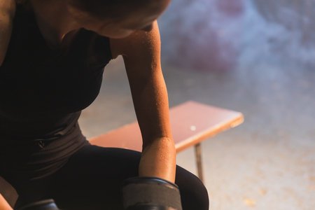 Strong sweaty athlete woman fighter resting after fight training on boxing ring. Strong girl tired after training session in gym. Strength fit body workoutの写真素材