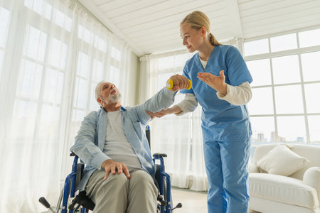 Support rehabilitation healthcare. Nurse helps old man patient in wheelchair picking up dumbbells. Paralyzed man in chair for people with disability doing sports exercise with nurse. Medical caregiverの写真素材