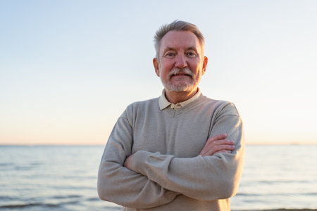 Outdoor portrait of confident stylish European middle aged senior man on beach. Older mature man smiling. Happy senior grandfather looking at camera close up face headshot portrait. Happy peopleの写真素材