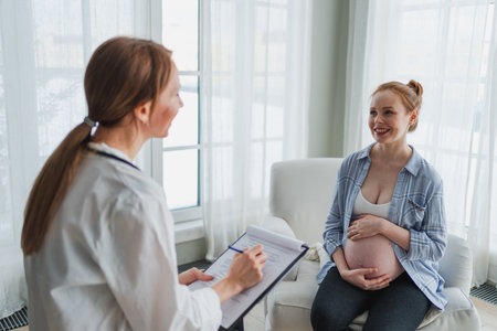 Female doctor examining pregnant woman in doctor office. Pregnant girl patient have consultation in hospital. Gynecologist doctor consulting patient about pregnancy. Visit to doctor medical checkupの写真素材