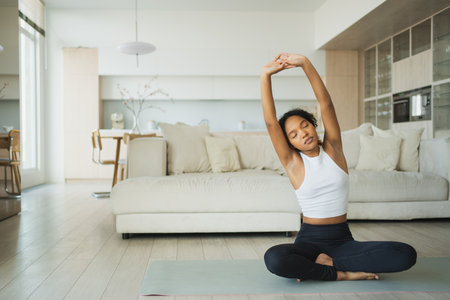Yoga fitness workout training. Healthy girl practicing yoga at home. Woman training doing sports exercise on yoga mat indoor. Girl have training workout for weight loss. Sport fitnessの写真素材
