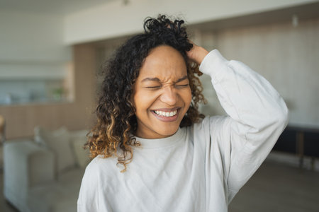 Beautiful African American girl with afro hairstyle smiling. Close up portrait of young happy black girl. Young African woman with curly hair laughing. Freedom happiness carefree happy people conceptの写真素材