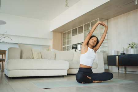 Yoga fitness workout training. Healthy African girl practicing yoga at home. Woman training Pilates doing sports exercise on yoga mat indoor. Girl have training workout for weight loss. Sport fitnessの写真素材
