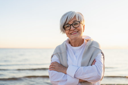 Outdoor portrait of confident stylish European middle aged senior woman. Older mature lady smiling on beach. Happy attractive senior female looking camera close up face headshot portrait. Happy peopleの写真素材
