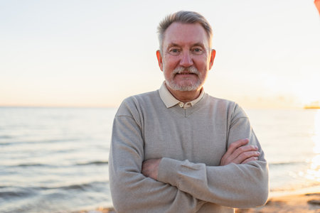 Outdoor portrait of confident stylish European middle aged senior man on beach. Older mature man smiling. Happy senior grandfather looking at camera close up face headshot portrait. Happy peopleの写真素材