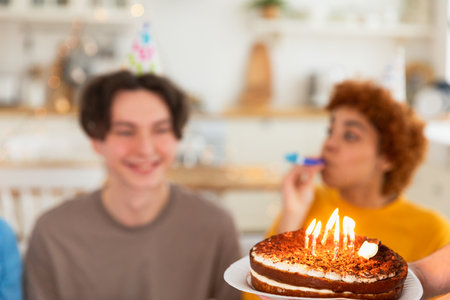 Make a wish. Burning candles on birthday cake ready for blowing out. Happy Birthday party. Friends wishes man happy birthday. People celebrating birthday party. Plate with birthday cake in handsの写真素材