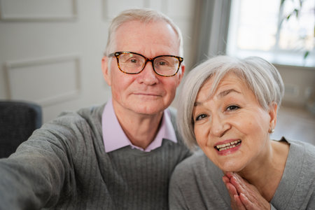 Happy senior woman man talk on video call with friends family. Mature old grandmother grandfather talking speaking with grown up children online. Older generation modern tech usage. Webcamera viewの写真素材