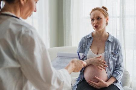 Female doctor examining pregnant woman in doctor office. Pregnant girl patient have consultation in hospital. Gynecologist doctor consulting patient about pregnancy. Visit to doctor medical checkupの写真素材