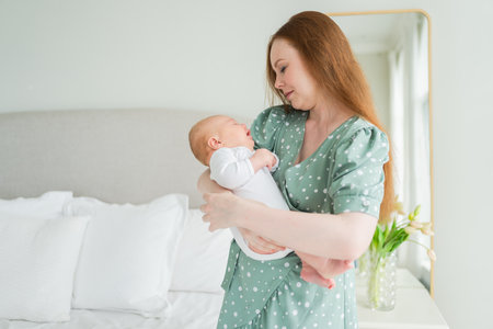 Happy family at home. Mother holding little toddler child daughter. Mom and baby girl relax playing having fun together at home. Mother hugs baby with love care.の写真素材