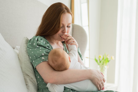 Happy family at home. Mother holding little toddler child daughter. Mom baby girl relax playing having fun together at home. Mother hugs baby with love care.の写真素材