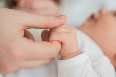 Happy family. Tiny newborn infant baby little hand on mother hand palm. Newborn baby holding parent...