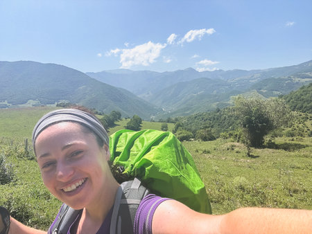 Hiking tourism adventure. Backpacker hiker woman taking selfie picture. Hiker girl lady tourist with backpack walking near mountain. Young happy woman enjoy hike trekking tourism active vacationの写真素材