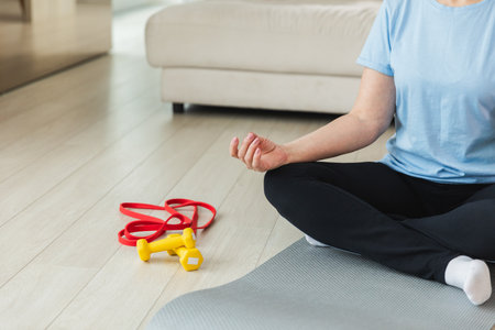 Yoga mindfulness meditation. Senior mature woman practicing yoga at home. Hands in chin mudra gesture. Adult old lady sitting in lotus pose meditating relaxing. Woman doing breathing practiceの写真素材