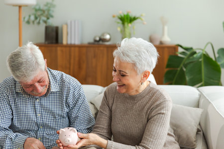 Saving money investment for future. Senior adult mature couple holding piggy bank putting money coin. Old man woman counting saving money planning retirement budget. Saving investment banking conceptの写真素材