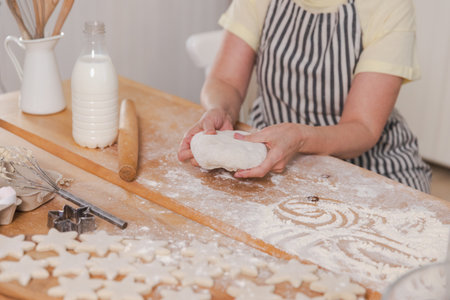 Senior woman cooking in kitchen, hands close up. Older mature lady grandmother hands knead dough bake cookies. Old grandma cook homemade food. Household housewife housework conceptの写真素材