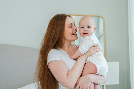 Happy family at home. Mother holding little toddler child daughter. Mom and baby girl relax playing...