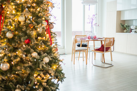 Classical Christmas decorated interior kitchen. Modern classic style interior design apartment dining room and Christmas tree with red golden ornament decorations. Christmas eve at homeの写真素材