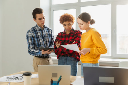 Teamwork brainstorm young professional team concept. Happy multiracial coworkers cooperating working together at office meeting. Diverse colleagues discussing project ideas editing documentationの写真素材