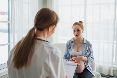 Female doctor examining pregnant woman in doctor office. Pregnant girl patient have consultation in hospital. Gynecologist doctor consulting patient about pregnancy. Visit to doctor medical checkupの写真素材