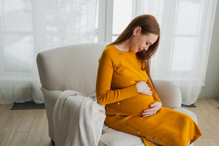 Pregnancy motherhood people expectation future. Pregnant woman with big belly sitting on chair near...