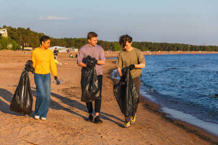 Earth day. Volunteers activists team collects garbage cleaning of beach coastal zone. Woman mans...