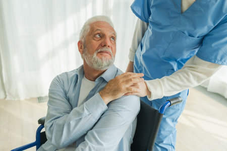 Help support retirement healthcare. Nurse helping old man in wheelchair. Patient and woman in nursing home for medical caregiver. Nurse taking care of paralyzed man in chair for people with disabilityの写真素材