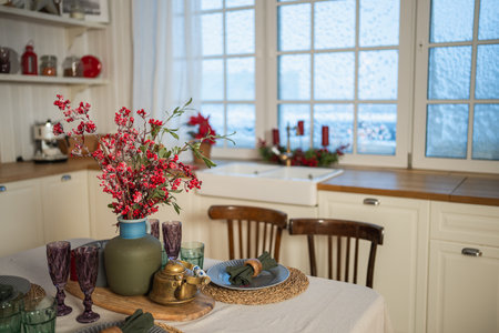 Classical Christmas decorated interior kitchen. Modern classic style interior design apartment dining with red frosty branches bouquet ornament Christmas decorations. Christmas eve at homeの写真素材