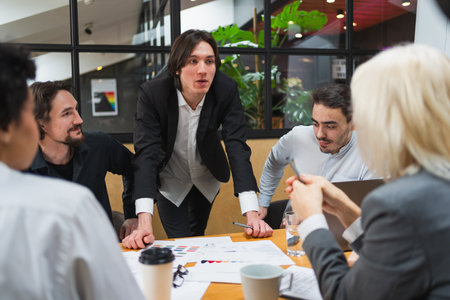 Teamwork brainstorm. Coworkers cooperating working together at office meeting. Colleagues discussing project ideas. Group of people in creative office discussing business. Young professional teamの写真素材
