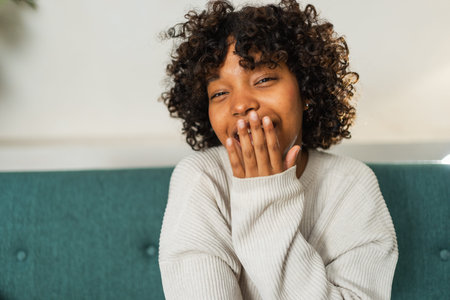 Beautiful African American girl with afro hairstyle smiling. Close up portrait of young happy black girl. Young African woman with curly hair laughing. Freedom happiness carefree happy people conceptの写真素材