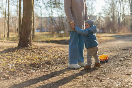 Happy family outdoor. Mother child on walk in park. Mom playing with baby son outdoor. Woman little...